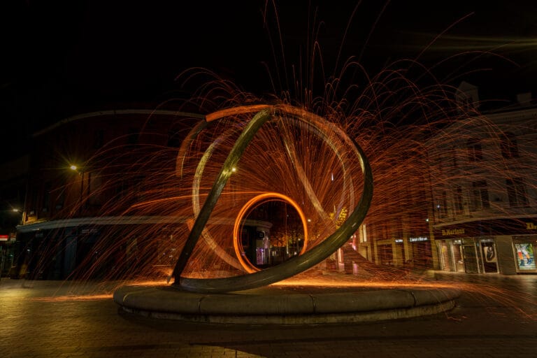 Steel wool sparks surrounding the Spirit of Belfast sculpture at night in Arthur Square, Belfast.